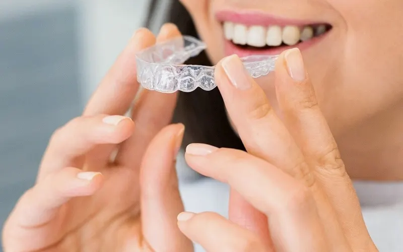 Paciente a colocar um alinhador transparente
